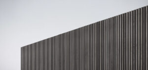 Realistiskt foto av en modern altan med spaljé, som ger ett mjukt ljusinsläpp och skapar en lugn atmosfär.